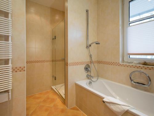 een badkamer met een douche en een bad bij Kaiservillen Heringsdorf - Ferienwohnung mit 1 Schlafzimmer und Balkon C23 in Heringsdorf