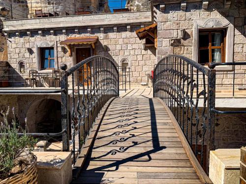 a wooden walkway in front of a stone building at Risus Cave Suites in Goreme