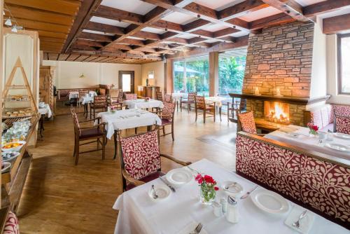 a restaurant with tables and chairs and a fireplace at Der Seewirt in Franking