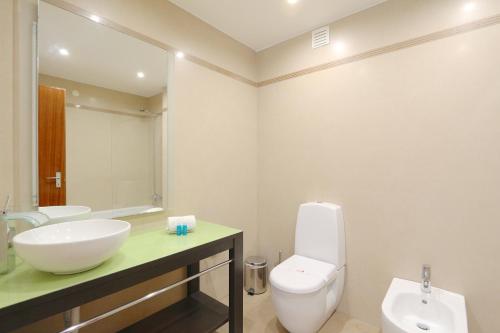 La salle de bains est pourvue d'un lavabo, de toilettes et d'un miroir. dans l'établissement Vilar do Jardim 59 - Clever Details, à Vilamoura