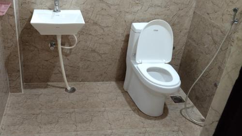 a bathroom with a toilet and a sink at GIRI NANDHANA RESIDENCY in Yelagiri