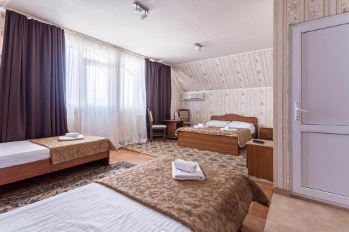 アドレルにあるГостевой дом "Дана" в 3 минутах от моряのベッド2台と窓が備わるホテルルームです。