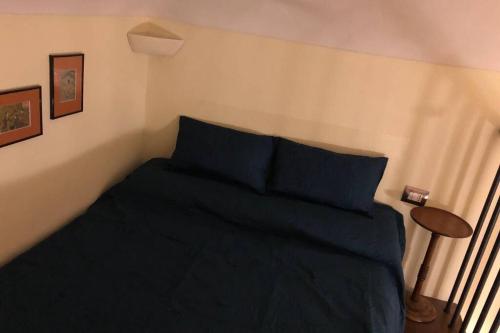 a bedroom with a bed with blue sheets and a table at Loft Il Teatrino nel cuore pulsante di Torino in Turin