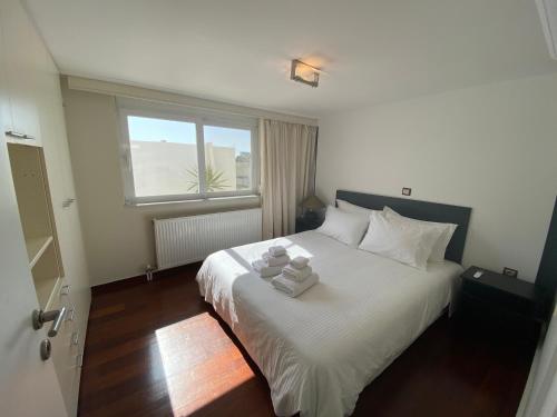 a bedroom with a white bed with towels on it at CityCenter Penthouse mini Private Pool with Hydromassage and Great Town View in Athens