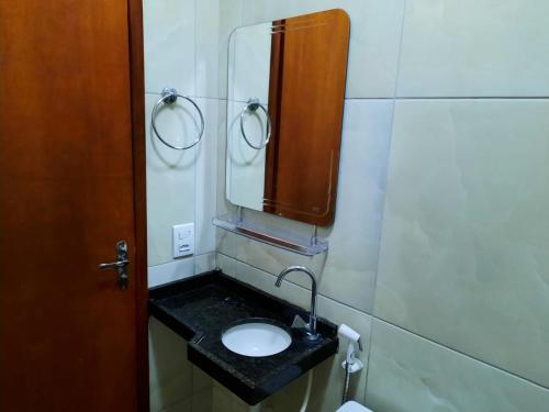 uma casa de banho com um lavatório e um espelho em Casa Neto&Lu em Guaramiranga