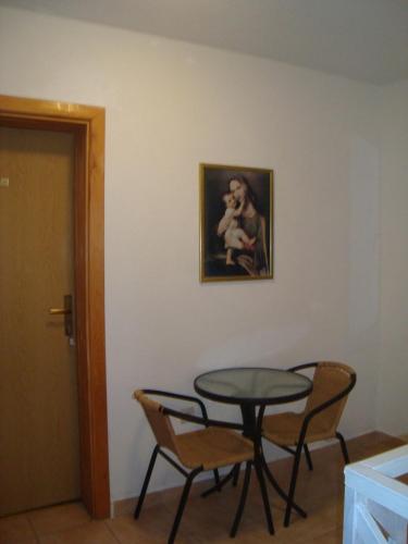 a table and chairs in a room with a painting at Pansion Ljubica in Međugorje