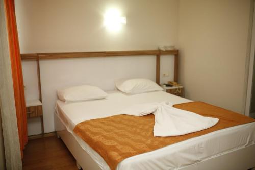 a bedroom with a bed with a towel on it at Özhan Hotel in Antalya
