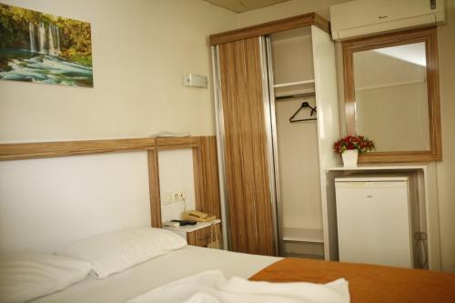 a bedroom with a bed and a mirror at Özhan Hotel in Antalya