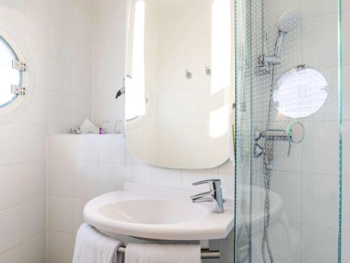 a bathroom with a sink and a shower with a mirror at ibis Heidelberg Hauptbahnhof in Heidelberg