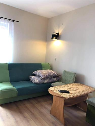 a living room with a green couch and a table at "Pokoje u Ireny"-pokój foto in Sztutowo