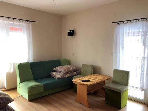 "Pokoje u Ireny"-pokój foto في شتوتوفو: غرفة معيشة مع أريكة خضراء وطاولة
