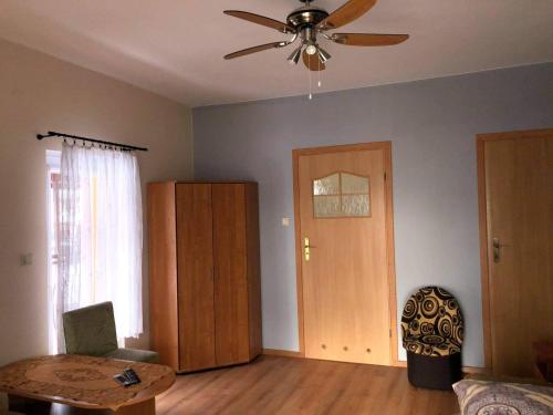 een woonkamer met een plafondventilator en een tafel bij "Pokoje u Ireny"-pokój foto in Sztutowo