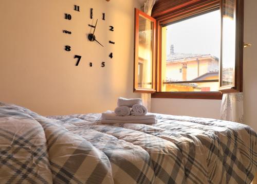 a bedroom with a bed with a clock on the wall at Emily House Vignola in Vignola
