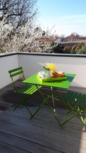 d'une table verte et d'une chaise sur un balcon. dans l'établissement Mimosas, à Andernos-les-Bains