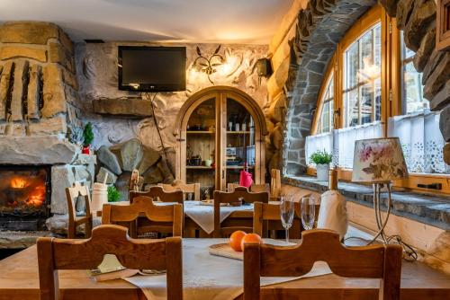 un ristorante in pietra con tavolo, sedie e camino di Willa Pod Niebem a Zakopane