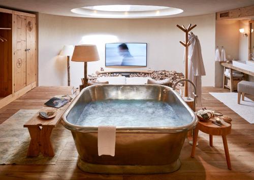 a large tub in a room with a living room at Maiensässhotel Guarda Val in Lenzerheide
