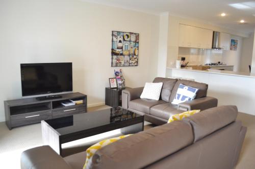 
a living room filled with furniture and a tv at North Coogee Beach House in Fremantle
