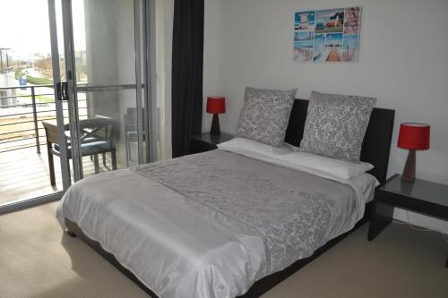 um quarto com uma cama grande e uma varanda em North Coogee Beach House em Fremantle