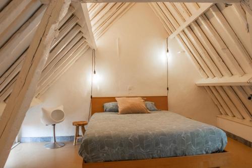 - une chambre avec un lit dans une pièce dotée de plafonds en bois dans l'établissement Cosy House near market, à Bruges