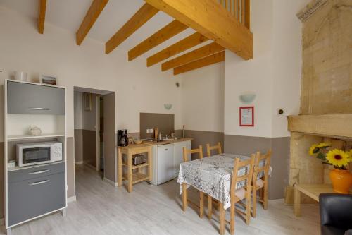 a kitchen and dining room with a table and chairs at Logis Andraud Studios in Saint-Émilion