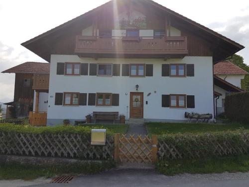 una gran casa blanca con una valla delante en Haus Echtler en Hopferau