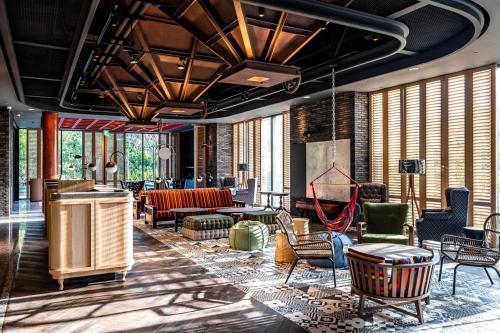 a lobby with chairs and tables and windows at Just Sleep Tainan in Tainan