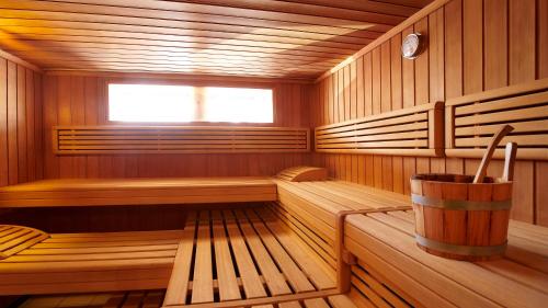 a wooden sauna with a bucket in it at Hotel TURNA Malbun in Malbun