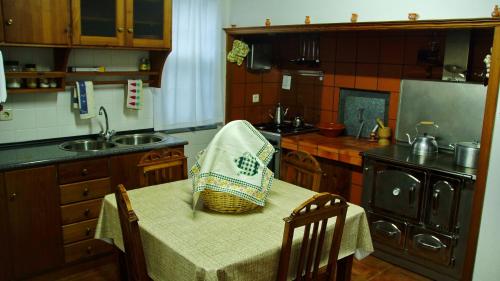 a kitchen with a table with a basket on it at PICO HOLIDAY RENTALS, Casa Do Avô Faidoca in Calheta de Nesquim
