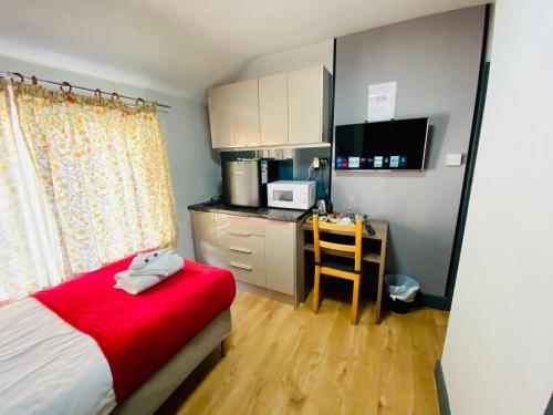 a bedroom with a bed and a desk with a microwave at Hollybush Guest House in Oxford