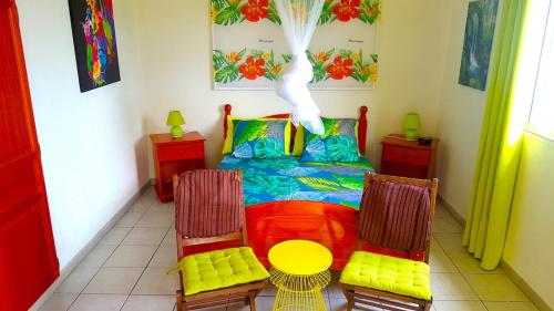 a room with a bed and two chairs and a table at Les pieds dans l'eau in Tartane