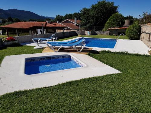 una piscina con 2 tumbonas junto a ella en Casa Barros, en Tui