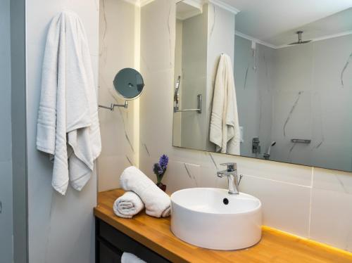 a white bathroom with a sink and a mirror at Klelia Beach Hotel by Zante Plaza in Kalamaki