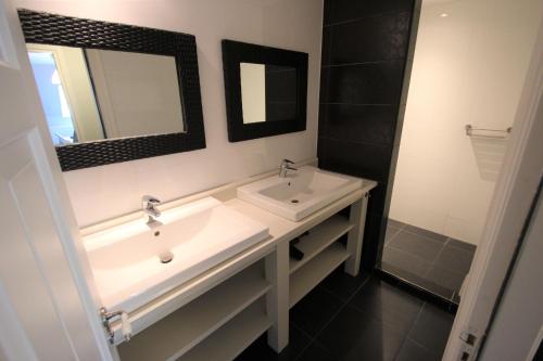 a bathroom with two sinks and a mirror at Verblijf bij Bynt in Sneek