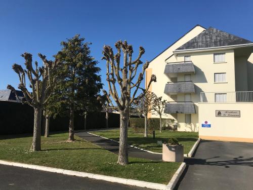 a house with trees in front of it at Cabourg - Bel appartement lumineux avec balcon dans résidence privée in Cabourg