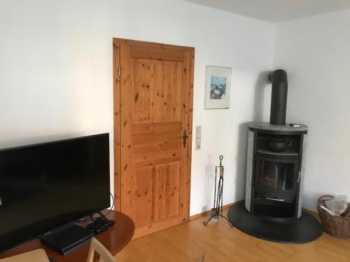 a living room with a television and a wood stove at Ferienwohnung Hanns in Kiel