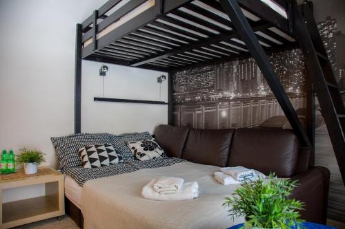a room with a bed with a leather couch at Apartament dwuosobowy203, 310,410, in Krynica Zdrój