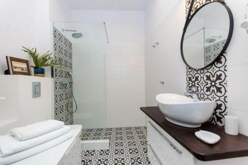 ein Bad mit einem Waschbecken und einem Spiegel in der Unterkunft Pirat Rentyear Apartments in Jelitkowo