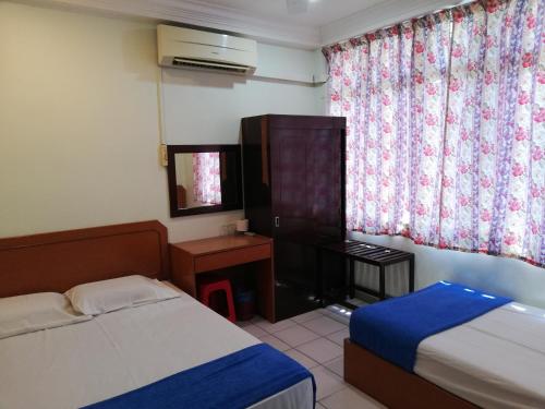 龙运Sri Gate Hotel的有两张床和一扇窗户的酒店房间