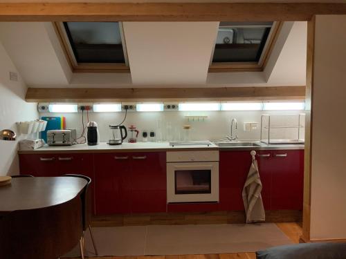 eine Küche mit roten Schränken und einem Waschbecken in der Unterkunft Dove Cottage (Annex) in Workington