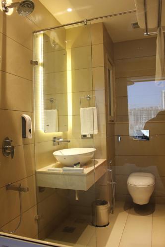 a bathroom with a sink and a toilet at Anande (The Boutique Hotel) in Sohāna