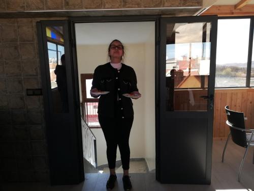 a woman standing in a doorway with a plate of food at Hotel School Ersat Azrou in Azrou