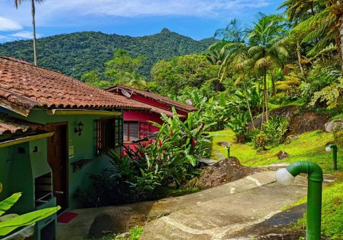 a house with a mountain in the background at Chalés Terras Altas de Paraty in Paraty