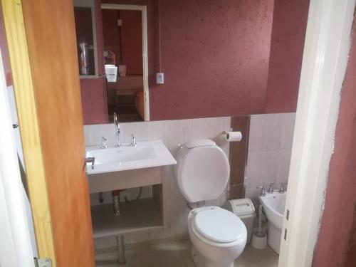 a bathroom with a toilet and a sink at COQUENA Departamentos in La Rioja