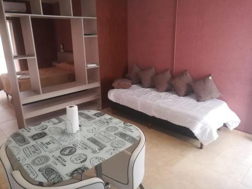 Un dormitorio con una cama y una mesa con una vela. en COQUENA Departamentos en La Rioja