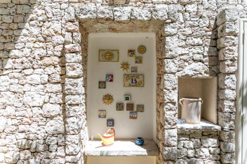 un muro di pietra con una porta con delle foto sopra di La Casa del Fico a Leuca