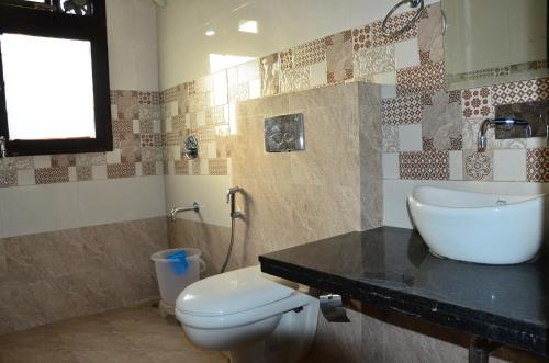 un baño con inodoro y lavabo en Brahma Paradise , A heritage haveli, en Pushkar