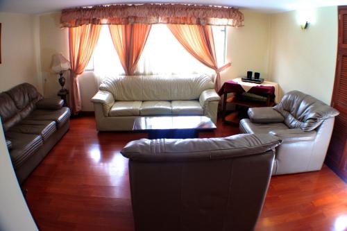a living room with leather furniture and a large window at Hotel Santa Isabel 2 in Ipiales