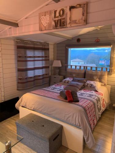 a bedroom with a large bed with a window at Chalet de charme tout confort in Les Adrets de l'Esterel