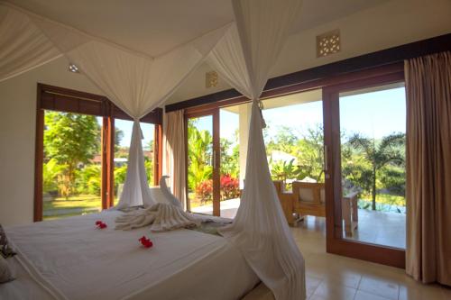 เตียงในห้องที่ Villa Shantiasa Bali