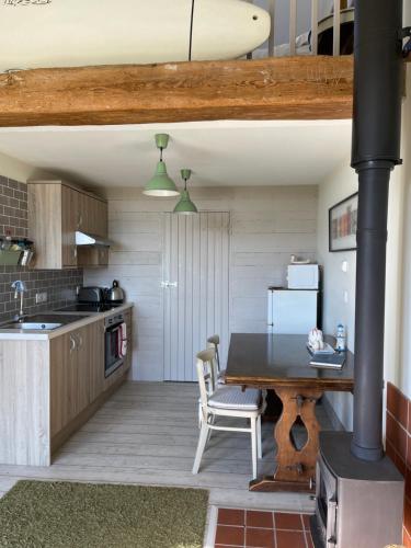 a kitchen with a table and a stove at Surf Shack 1-Bed Cottage Sleeps 2 Pet Friendly in Shorwell